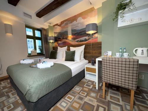 a bedroom with two beds and a painting on the wall at Boutique Provincja Winebar & Rooms in Olsztyn