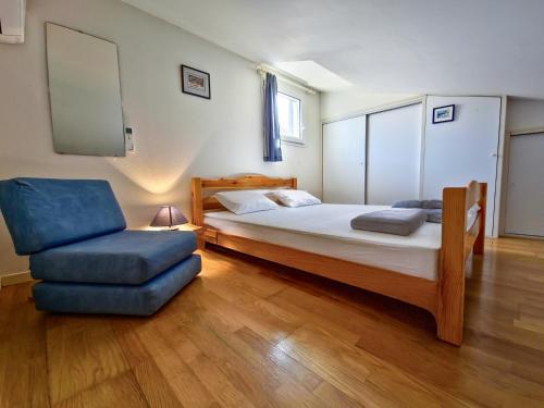 une chambre avec un lit et une chaise dans l'établissement Le Mazet à la mer WiFi Clim Parking, à Cavalaire-sur-Mer