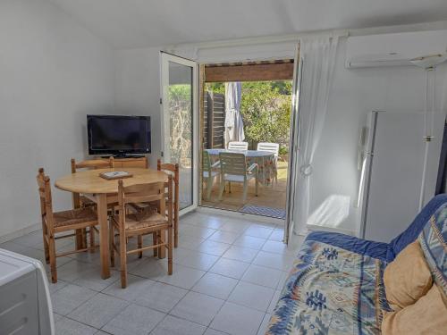 un salon avec une table et une télévision dans l'établissement Le Mazet à la mer WiFi Clim Parking, à Cavalaire-sur-Mer