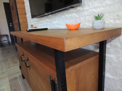 a wooden table with a television on a wall at Dunavski kutak in Veliko Gradište