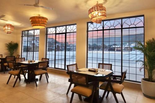 a restaurant with tables and chairs and large windows at Dev Niwas - Heritage Hotel in Būndi