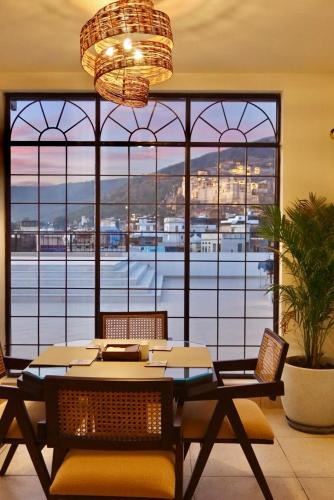 a dining room with a table and chairs and a large window at Dev Niwas - Heritage Hotel in Būndi