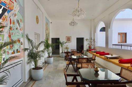 a restaurant with tables and chairs and plants at Dev Niwas - Heritage Hotel in Būndi