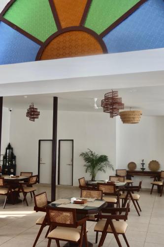 a room with tables and chairs and a colorful ceiling at Dev Niwas - Heritage Hotel in Būndi