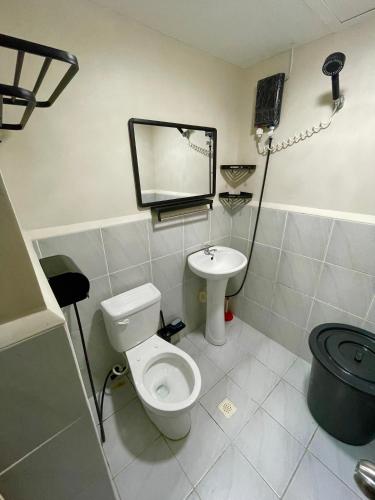 a bathroom with a white toilet and a sink at Cel Escapia in Lapu Lapu City