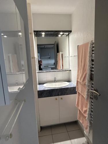 une salle de bain avec un lavabo et un miroir dans l'établissement Résidence Azureva - Richelieu, au Cap d'Agde