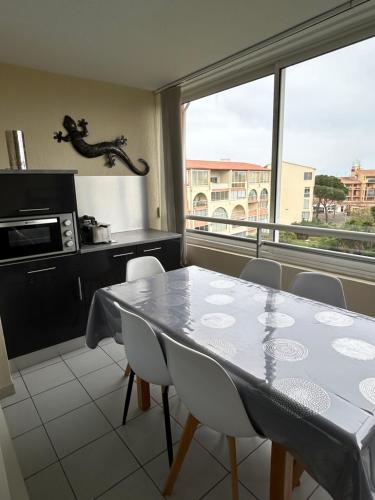 une cuisine avec une table et des chaises et une fenêtre dans l'établissement Résidence Azureva - Richelieu, au Cap d'Agde