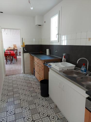 Il comprend une cuisine avec un évier et une table. dans l'établissement Maison rénovée à proximité de magnifiques randonnées, à Licq-Athérey