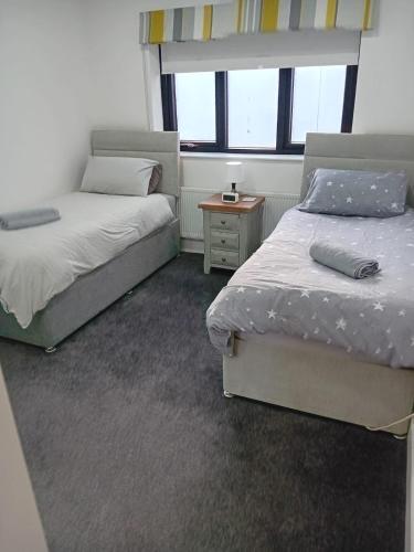 a bedroom with two beds and a night stand at Beach View, Portballintrae in Portballintrae