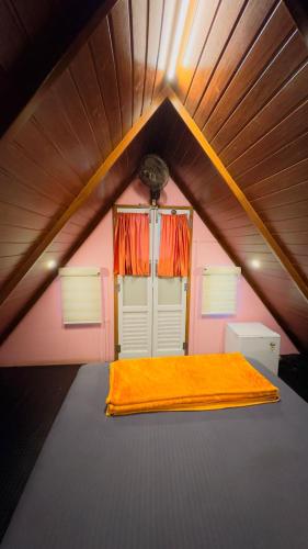 a room with a large bed in a attic at Ventos Tent Stay and Aframes in Anachal