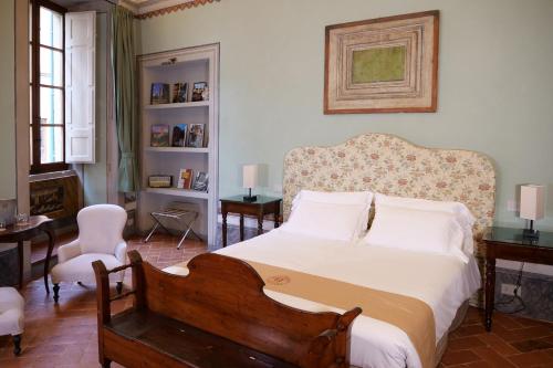 a bedroom with a large bed with white sheets at Delcorto Suites in Montepulciano