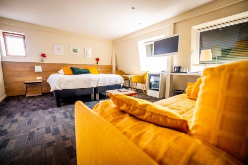 une chambre d'hôtel avec un lit et un canapé dans l'établissement Logis Hôtel Restaurant & Spa La Rochette, à Labaroche