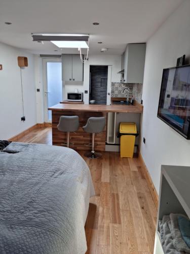a bedroom with a bed and a kitchen at Studio in Raynes Park