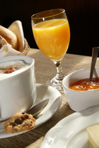a table with a cup of coffee and a glass of orange juice at Gasthof zur Post in Langenburg