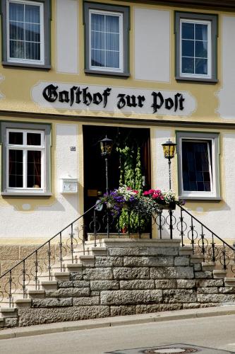 a building with a staircase in front of a door at Gasthof zur Post in Langenburg