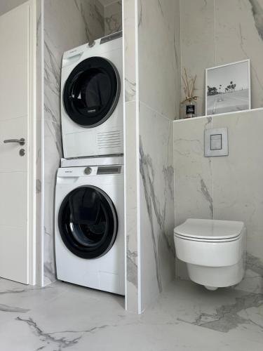 La salle de bains est pourvue d'un lave-linge et d'un sèche-linge. dans l'établissement Villa neuve avec piscine 3 chambres 140 m2, à Calvi