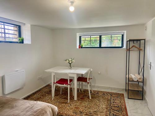 Cette chambre blanche dispose d'une table et d'un lit. dans l'établissement Studio proche Micropolis & Chu Minjoz, à Besançon