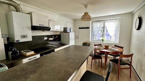 une cuisine avec une table et des chaises dans une cuisine dans l'établissement Au coeur de l'Auvergne, à Nohanent