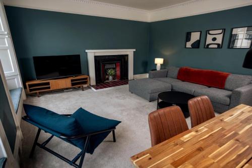 a living room with a couch and a television at Elegant 3BD Georgian Retreat in Perth City Centre in Perth