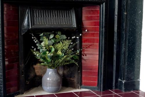 a vase with flowers in it sitting next to a building at Elegant 3BD Georgian Retreat in Perth City Centre in Perth