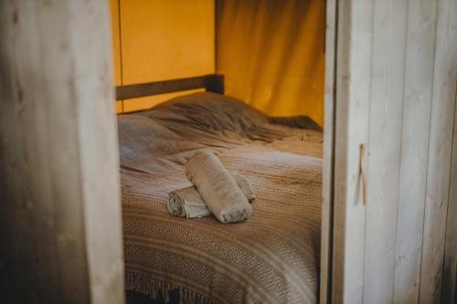 ŁawkiWolny Las Glamping na Mazurach的床上的毛巾反射