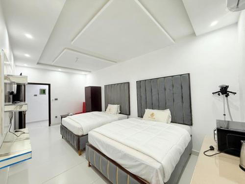 a bedroom with two beds and a television in it at Hotel Tulip Inn, Gulberg in Lahore