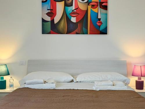 a bedroom with a bed with a painting on the wall at Coppito Apartment in Coppito