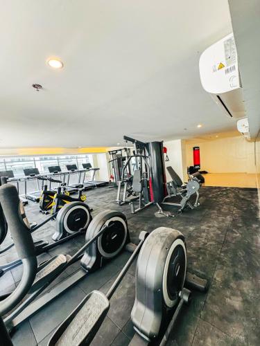 a gym with several treadmills and exercise machines at Luxury Penthouse & High-Floor Hotel near City of Dreams, Airport, Okada, and Solaire Casino in Manila