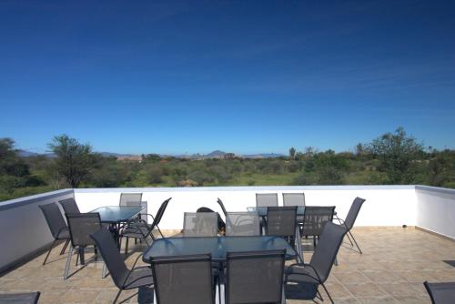 a group of tables and chairs on a balcony at Little Bush Guesthouse in Omaruru