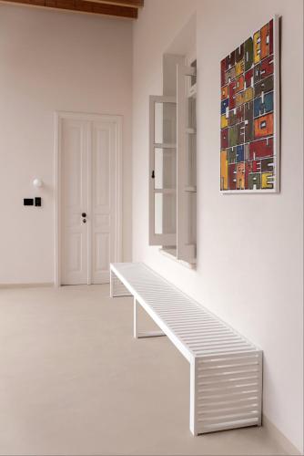 a white room with a bench and a painting on the wall at Heart Hotel in Limassol