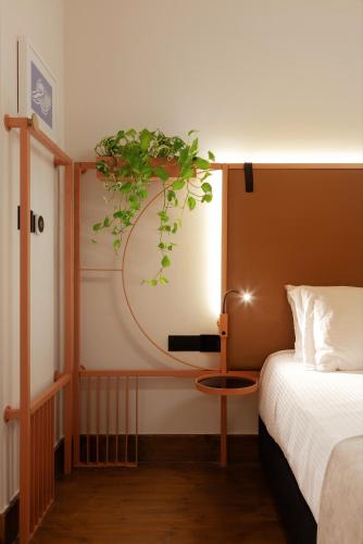 a bedroom with a bed and a plant on the wall at Heart Hotel in Limassol