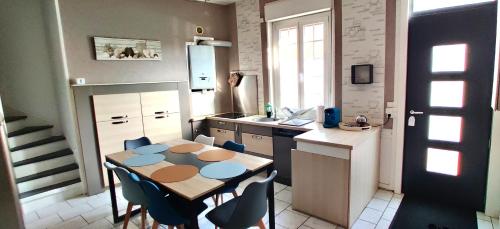 une cuisine avec une table et des chaises dans l'établissement L'Aronnax - Maison -Jardin - Idéal Long Séjour, à Pont-de-Metz