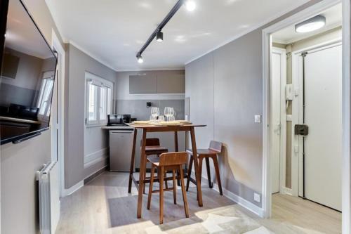 une cuisine avec une table et des chaises dans une pièce dans l'établissement Apartment Centre de Paris Le Marais, à Paris