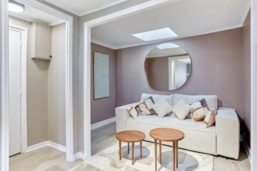 - un salon avec un canapé blanc et un miroir rond dans l'établissement Apartment Centre de Paris Le Marais, à Paris