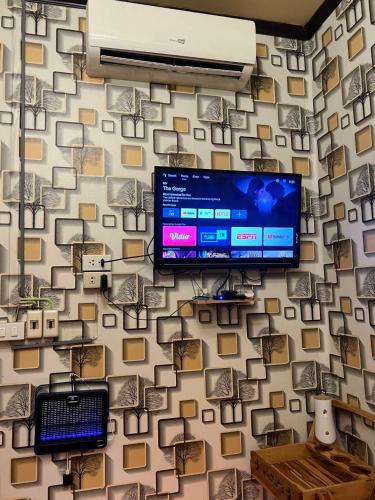 a room with a wall with a tv on it at Airi Homestay in Suvarnabhumi Airport
