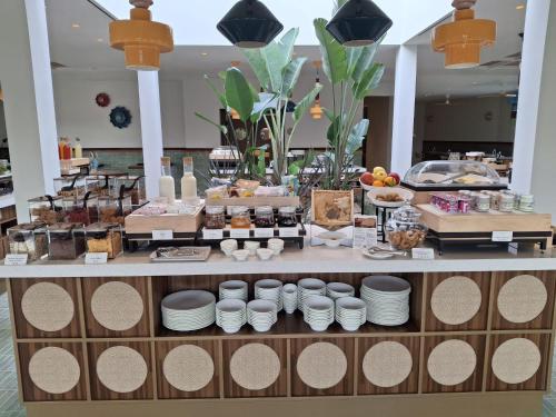 a buffet with plates and food on a counter at Terradamari Resort & Spa Marina di Modica,Tapestry by Hilton in Marina di Modica