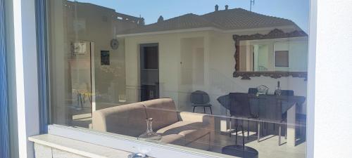 a reflection of a living room with a couch in a window at Tominettihome in Verbania