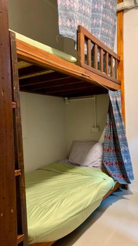 ein Etagenbett in einem Zimmer mit einem grünen Bett in der Unterkunft Pakham hostel in Pai