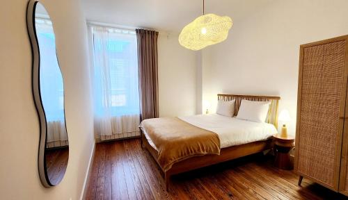 a bedroom with a bed and a large mirror at Le Jardin d'Eden in Ay-sur-Moselle