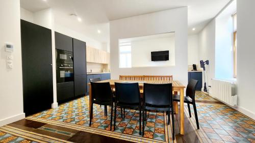 a kitchen with a wooden table and black cabinets at Le Jardin d'Eden in Ay-sur-Moselle