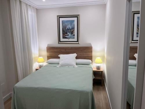 a bedroom with a large bed with two lamps at Mirador de Sanlucar 3 in Sanlúcar de Barrameda