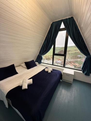 a bedroom with two beds and a large window at Qızıl Farel (Ailəvi İstirahət Mərkəzi) in İsmayıllı