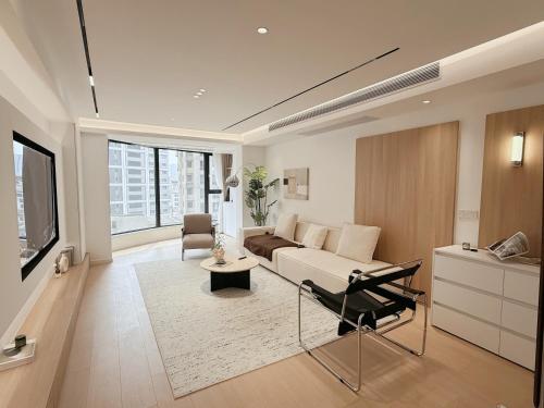 a living room with a couch and a tv at Pure Home-Near the Bund enjoys the beautiful scenery of the Bund 3-bedhome close to Yuyuan Garden Huaihai Road and Nanjing Road Pedestrian Street in Shanghai