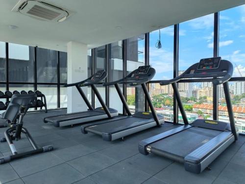 a row of treadmills in a gym with windows at Georgetown Ins Cozy Suites 2BR in George Town
