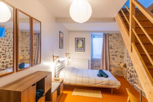 - une chambre avec un lit dans une pièce avec des escaliers dans l'établissement Charmant T2 Centre historique, à Vals-les-Bains