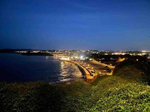 a view of a beach at night with lights at The Goodrington Sands- Apart Hotel in Paignton