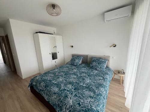 une chambre avec un lit avec une couette bleue dans l'établissement Central Park Cannes, à Cannes
