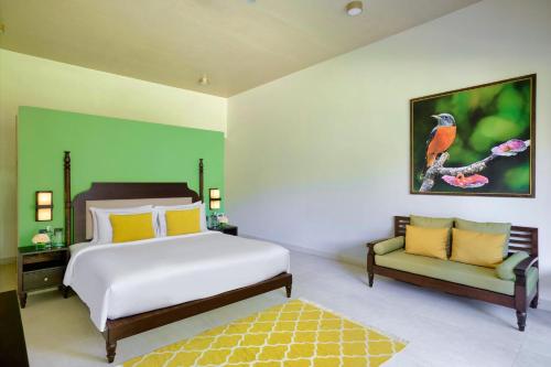 a bedroom with a king sized bed and a couch at Gateway Coorg in Madikeri