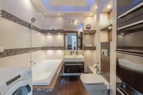 a bathroom with a tub and a toilet and a sink at Horyzont Apartamenty- Apartament Nadmorski, blisko PKP i centrum in Kołobrzeg