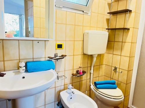 un baño con inodoro y lavabo en Villa Pinocchia, en Bibione